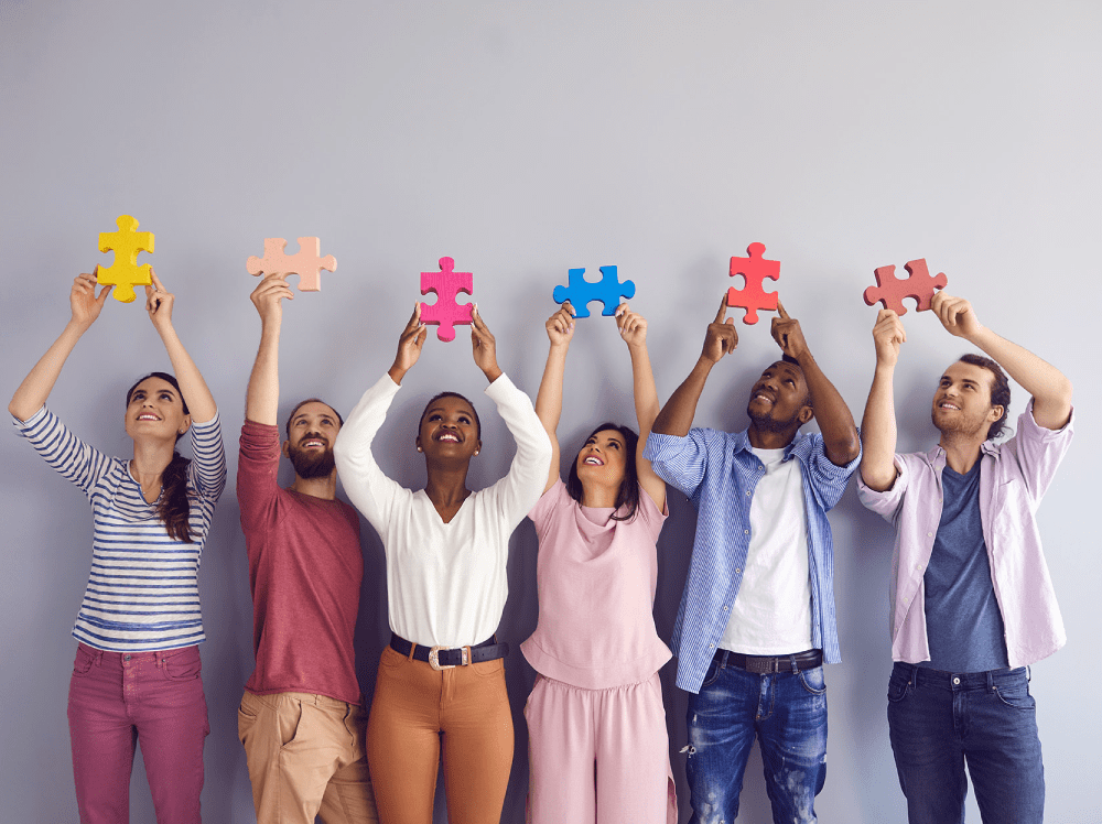 A group of people holding puzzle pieces.